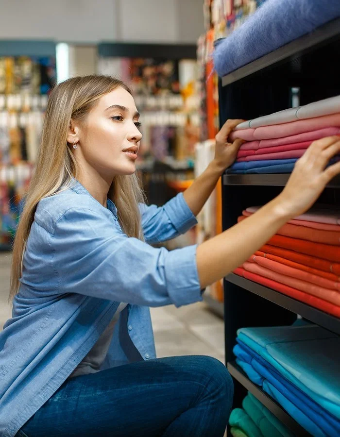 Saleswoman measures fabric in textile store
